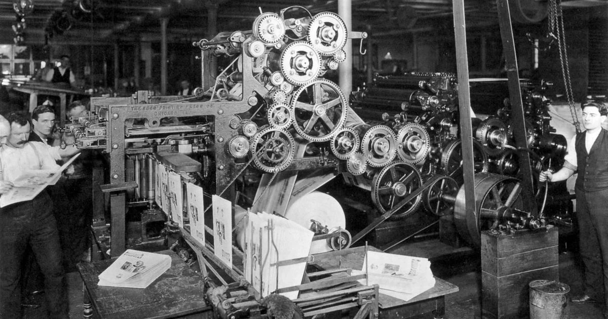 Taller histórico de impresión periódica con prensa mecánica y ejemplares impresos.