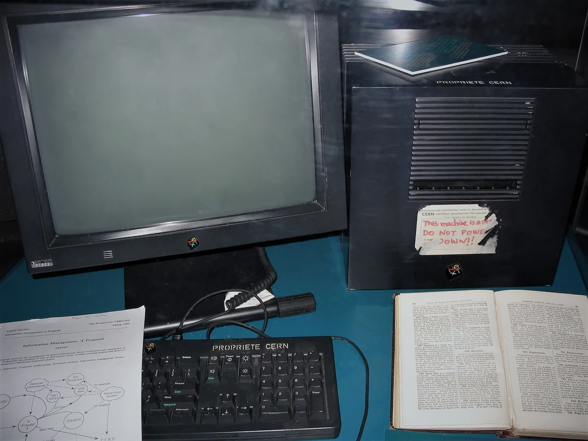Ordenador NeXTcube utilizado como primer servidor de la World Wide Web, expuesto junto a una pantalla y documentos.