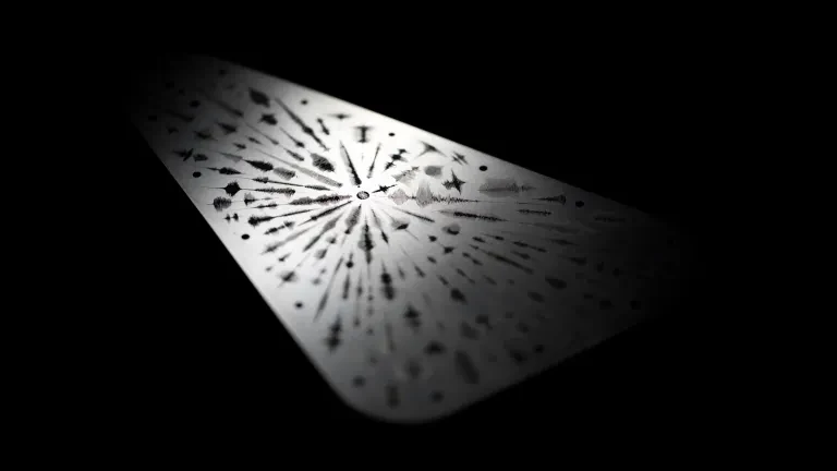 Cara exterior de la placa de Europa Clipper con formas de onda grabadas que representan la palabra agua en numerosas lenguas.