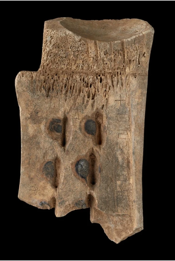 Fragmento óseo con inscripción oracular que registra un eclipse lunar, conservado por la British Library.