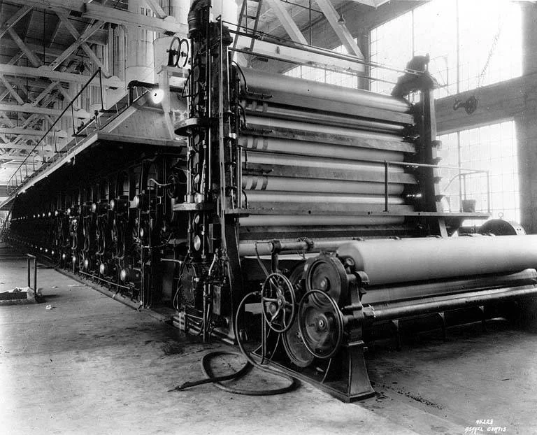 Máquina industrial de fabricación de papel en una fotografía histórica de la primera mitad del siglo XX.