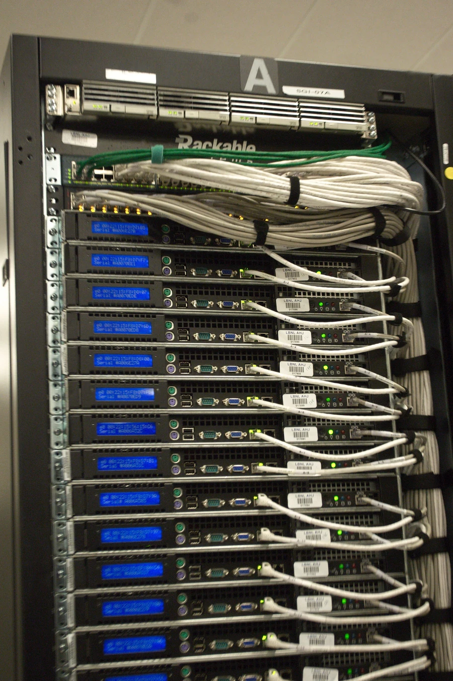 Parte posterior de un rack de servidores con conexiones de red y equipos apilados.