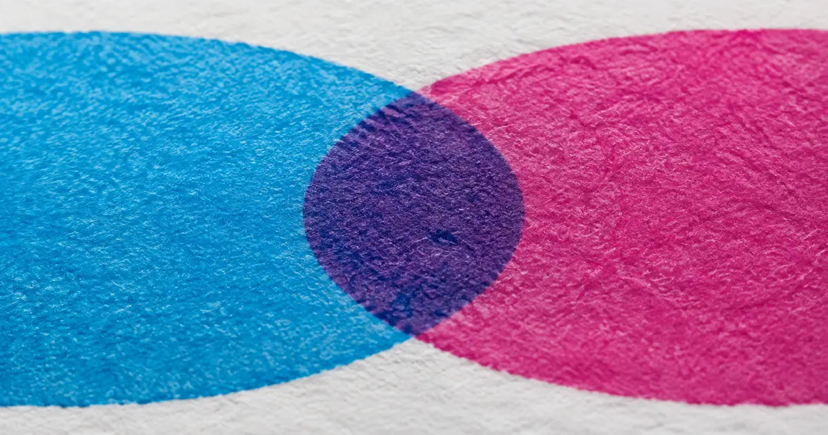 Representación conceptual de tinta cian y magenta superpuestas sobre papel