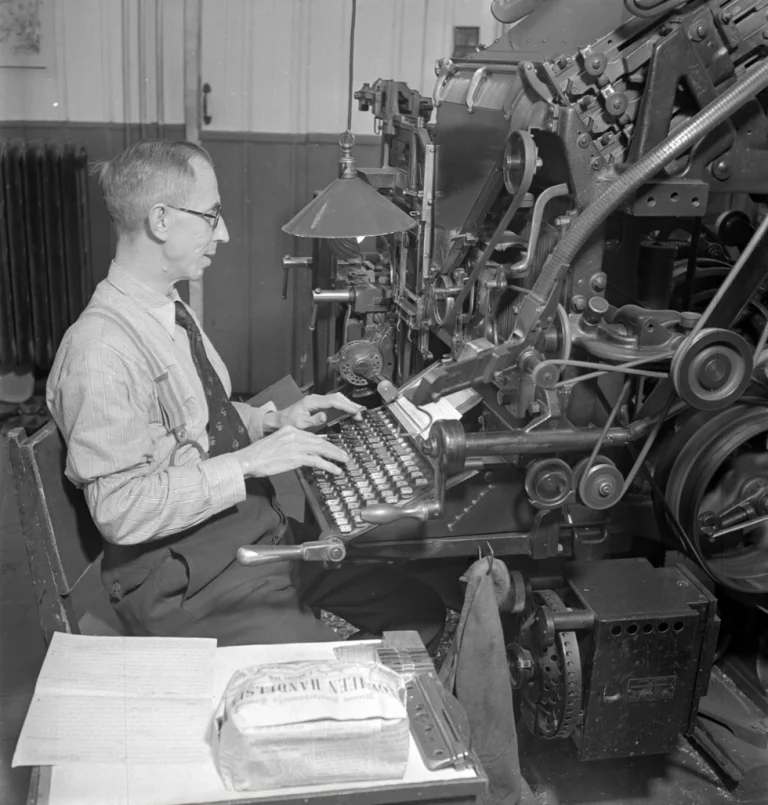 Operarios trabajando con una máquina Linotype en un taller de composición tipográfica.